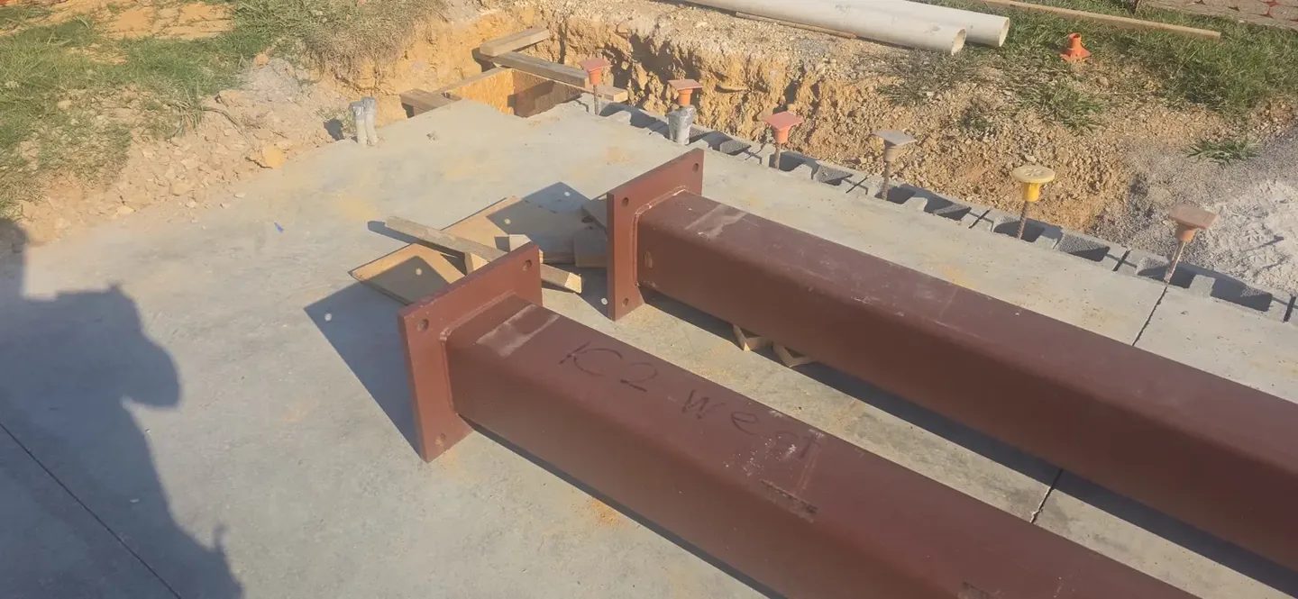 Shortened steel beams with end plates welded in place
