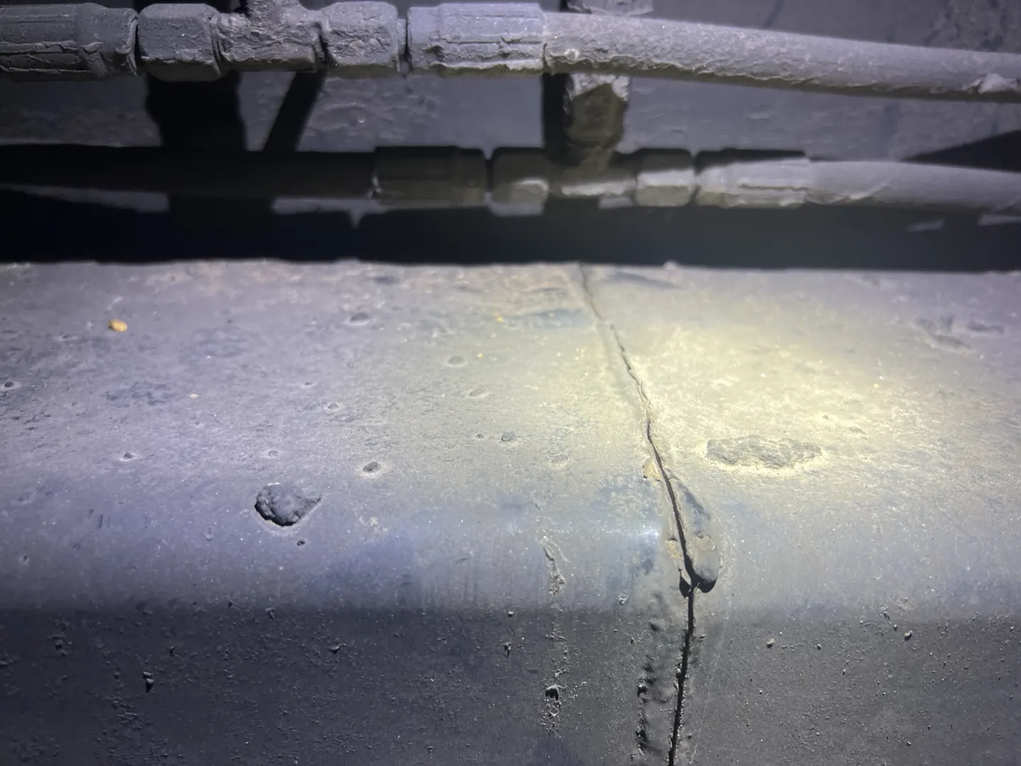 Close view of the semi-trailer frame crack beneath the existing lines