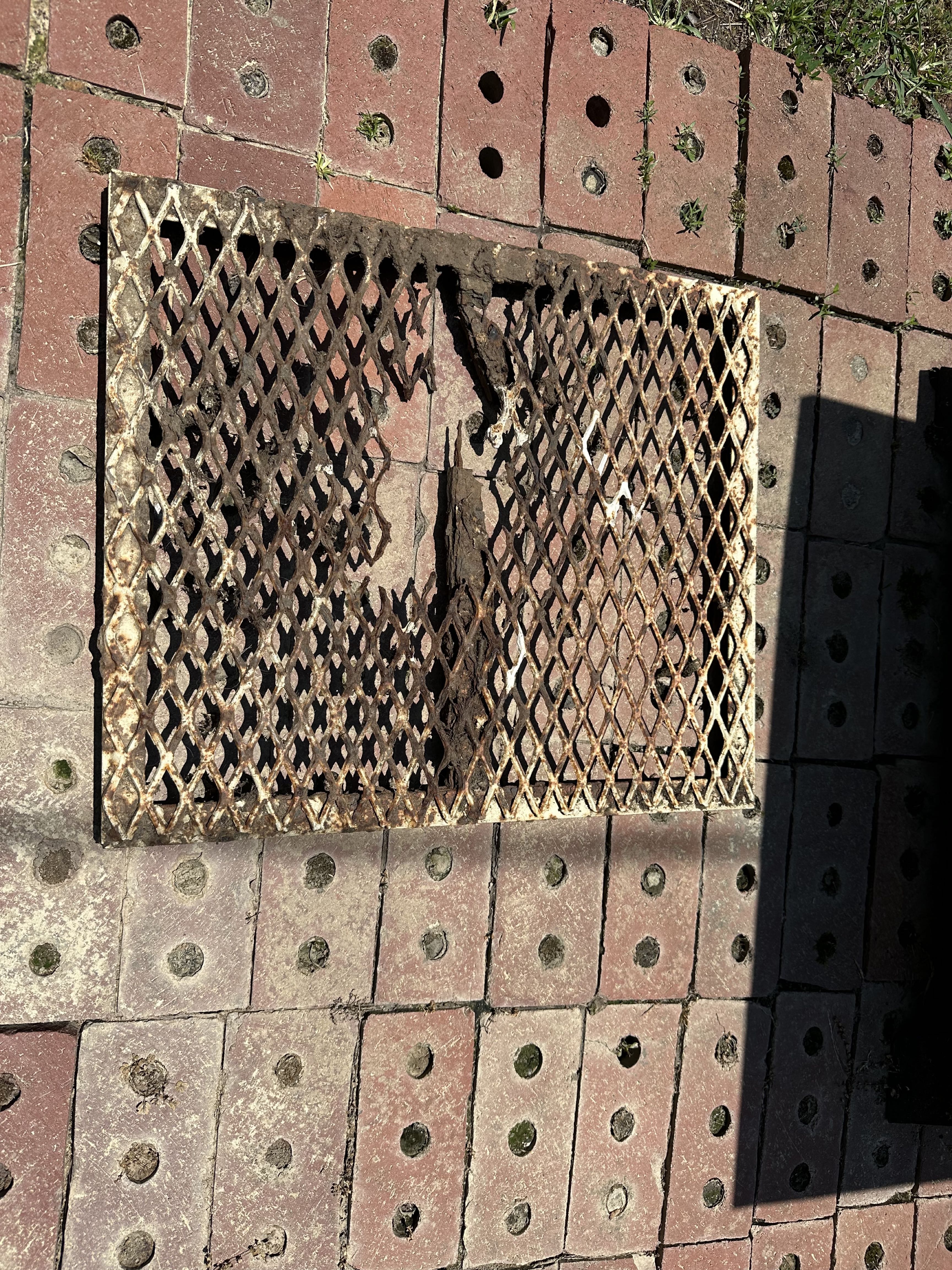 Rusted and damaged expanded-metal grill grate before repair