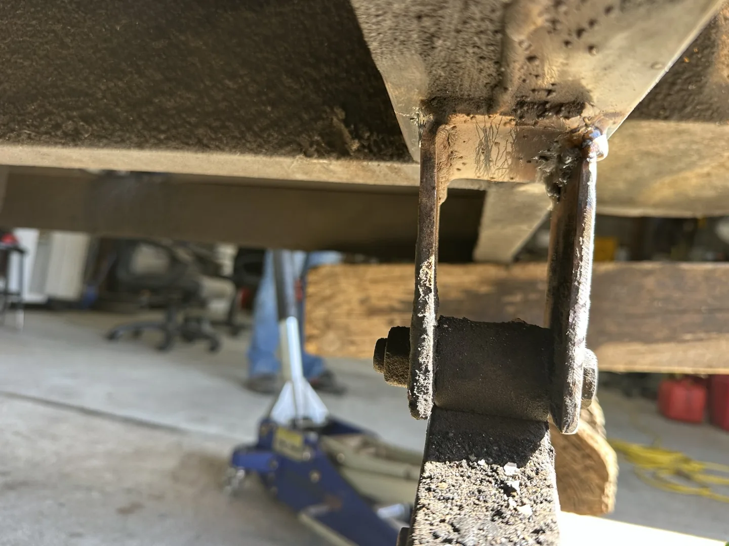 Inside view of the repaired spring bracket and weld beneath the trailer frame