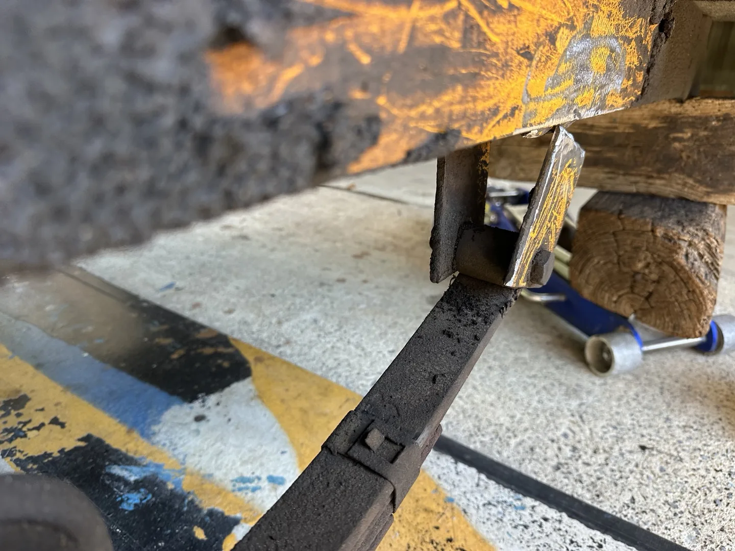 Side view of the separated steel spring bracket beneath the trailer frame