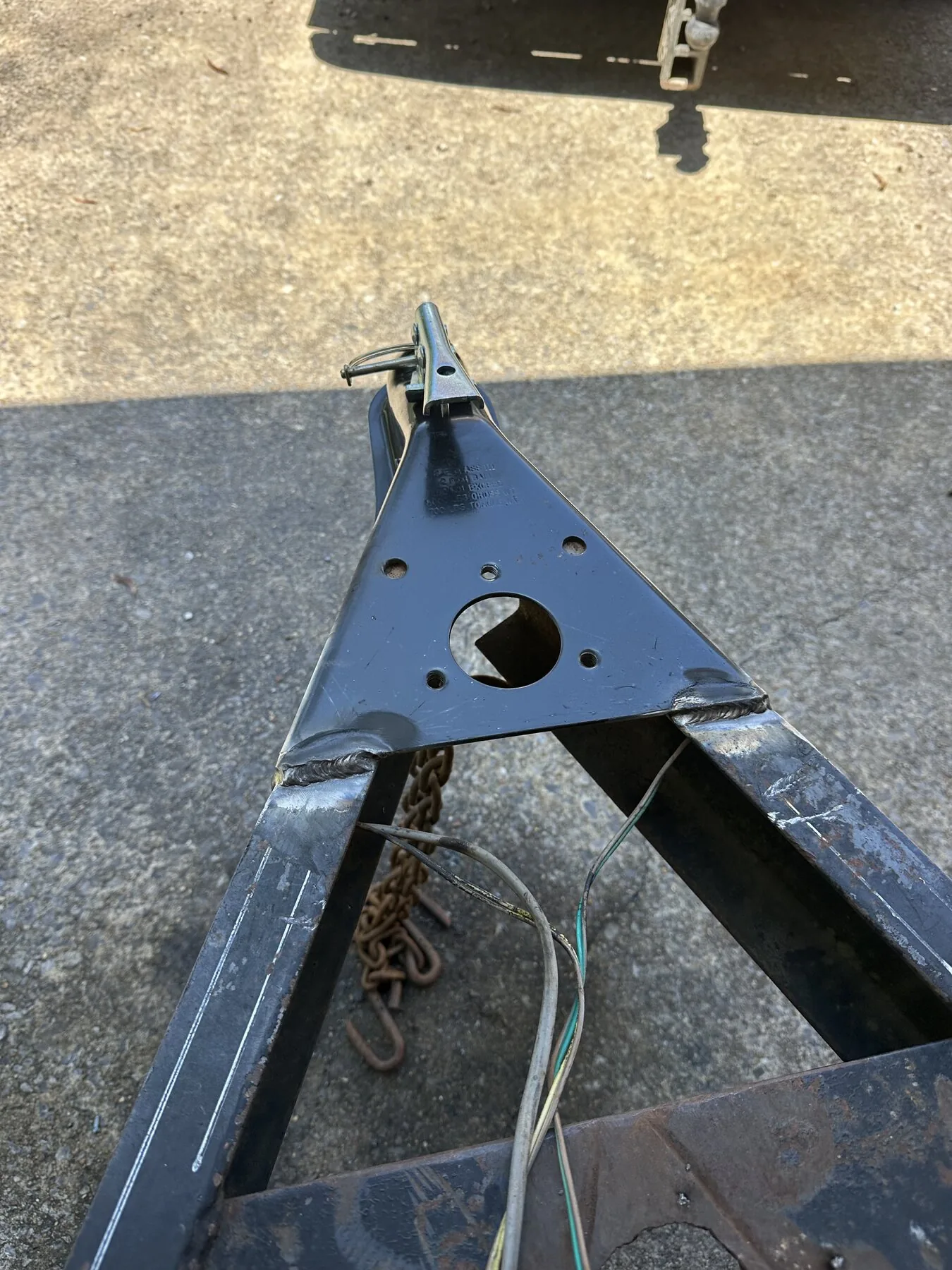New trailer hitch fitted to the trailer tongue during repair in Anniston